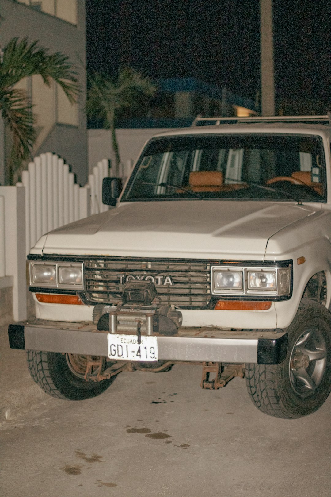 a-white-truck-parked-in-front-of-a-white-fence-yke4xukl4n0